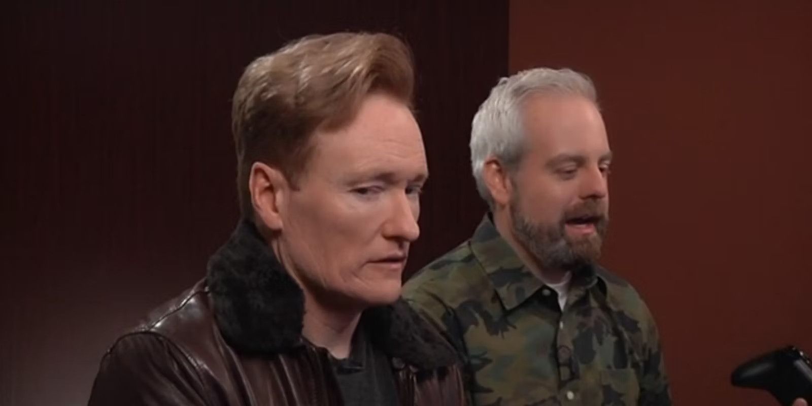 Conan O'Brien looks away as Aaron Bleyaert plays a game on the "Clueless Gamer" segment on Conan.