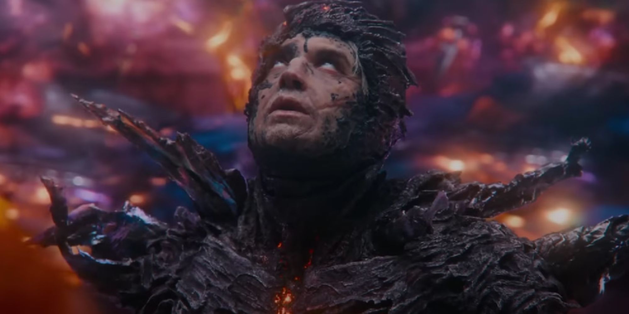 Dark Flash inside a storm with stone-like shards encrusting him, looking up, eyes rolled back, in The Flash