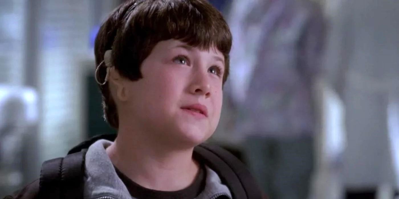 A young Dylan Minnette as Ryan wearing a hearing device and looking off-camera in Grey's Anatomy.