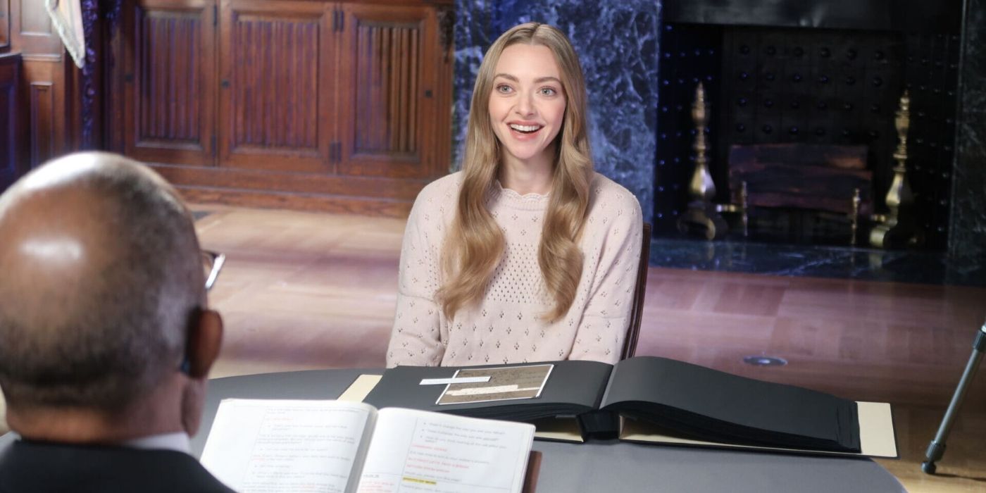 Amanda Seyfried is seated across from Henry Louis Gates, Jr., smiling brightly during her session on Finding Your Roots Season 11. She’s wearing a light-colored sweater.