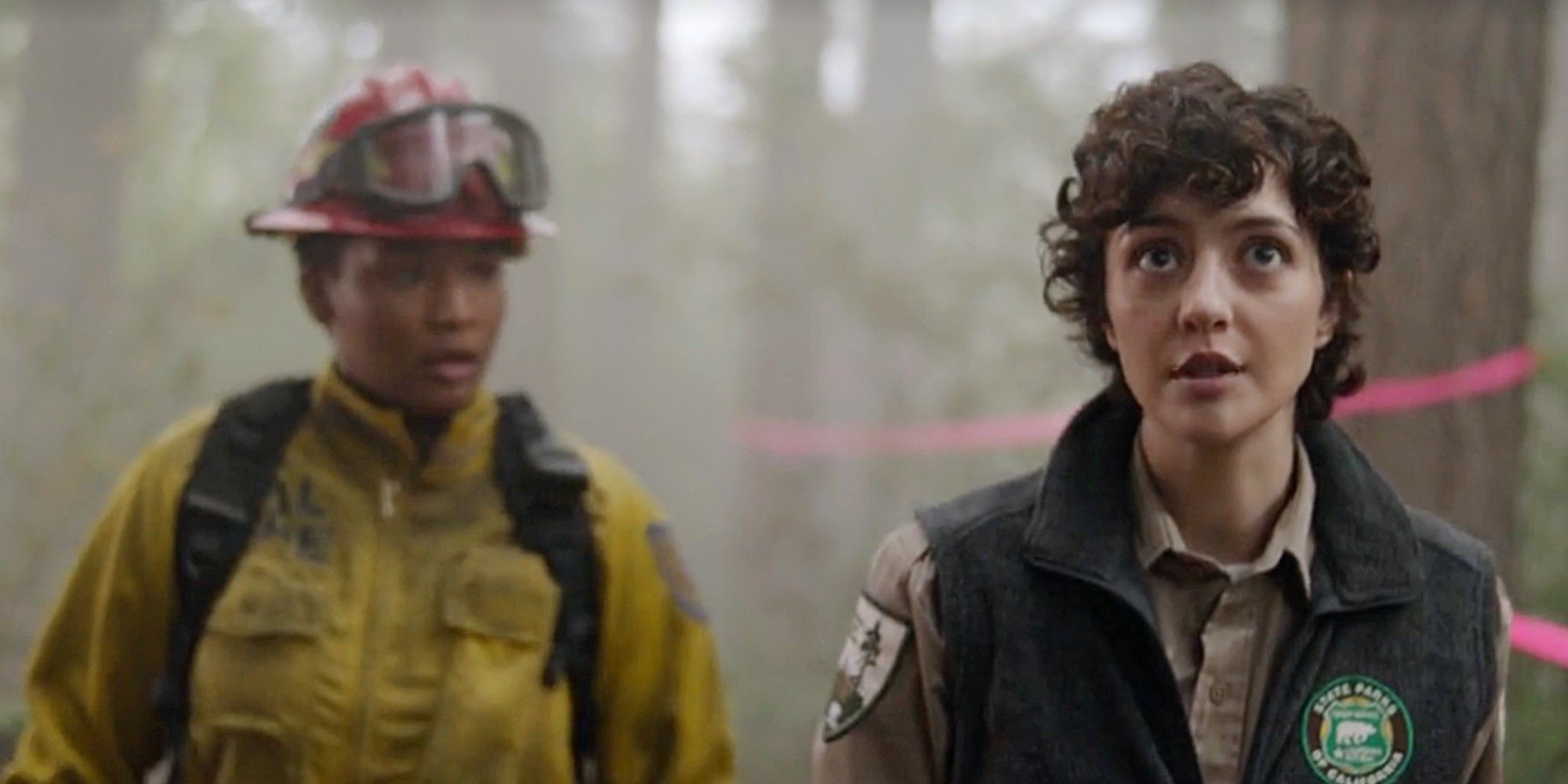 Eve standing behind Francine in the woods in Fire Country