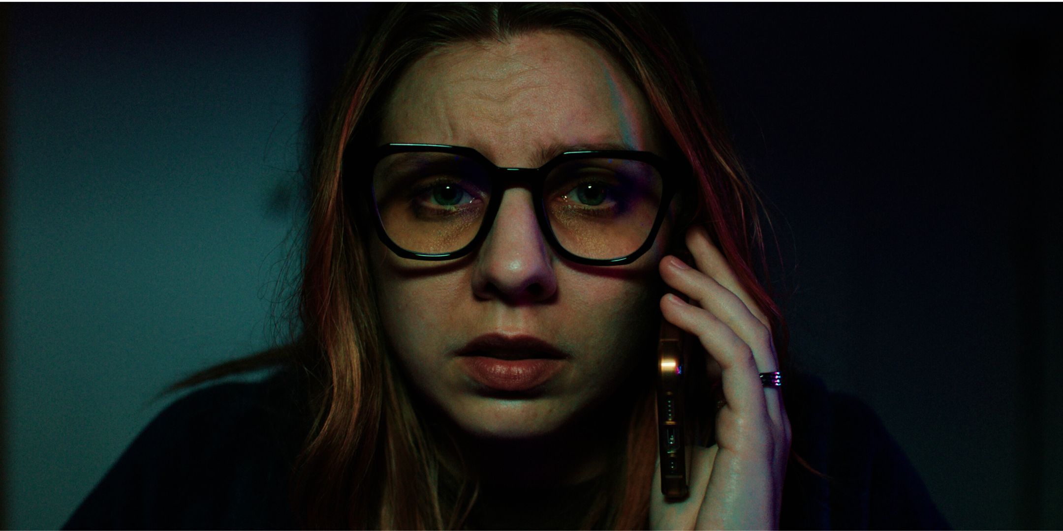 Nicole Pastor as Katie wearing glasses on the phone in Freelance horror