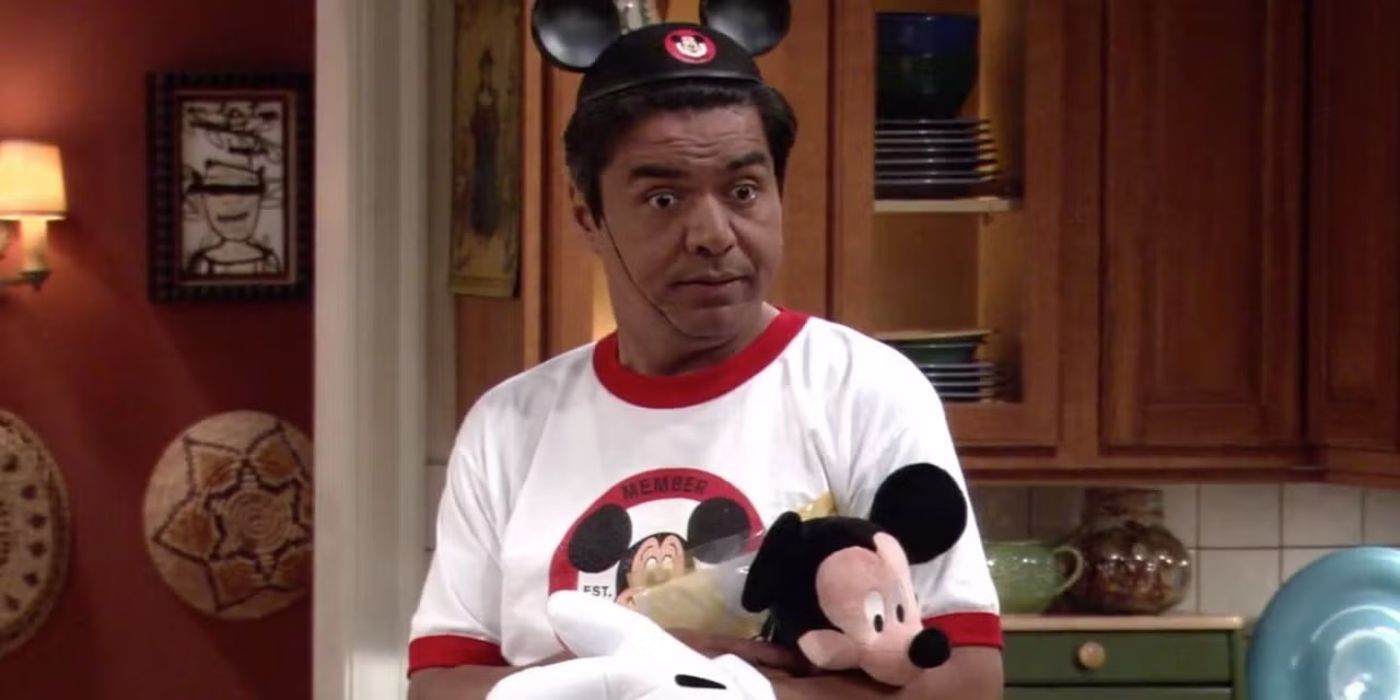George Lopez dressed in items from Disneyland and holding a stuffed Mickey Mouse on George Lopez.