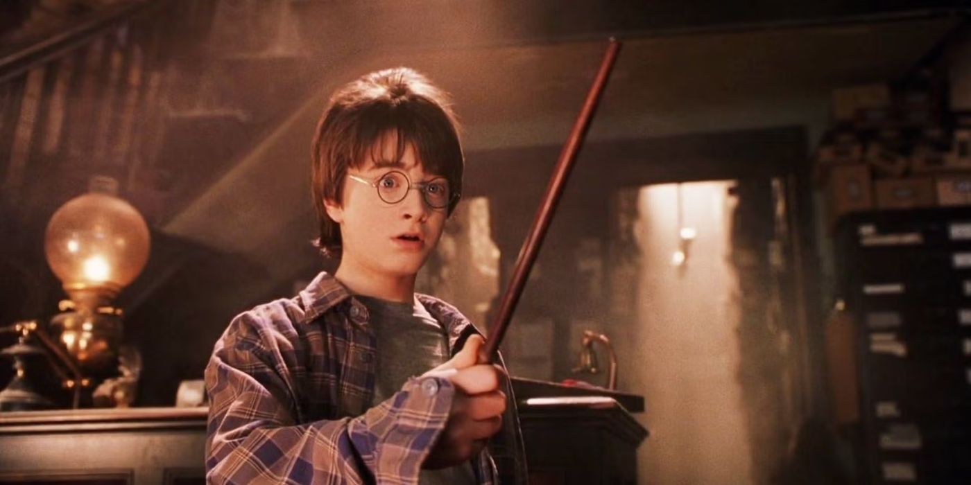 Harry Potter, played by Daniel Radcliffe, holding a wand in 'Harry Potter and the Sorcerer's Stone.'