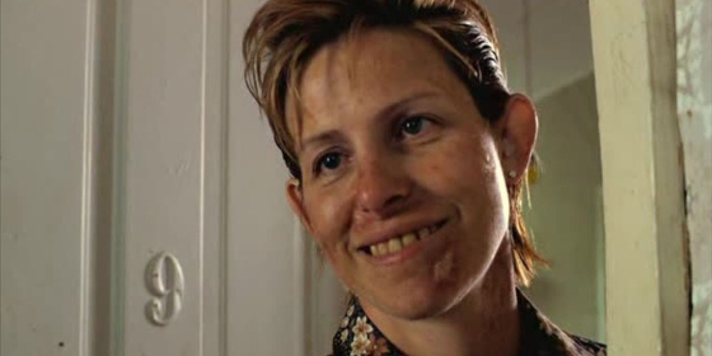 Lois Broderick (Deneen Frazier) stands in a doorway with a half-formed smile and face splotched with acne.