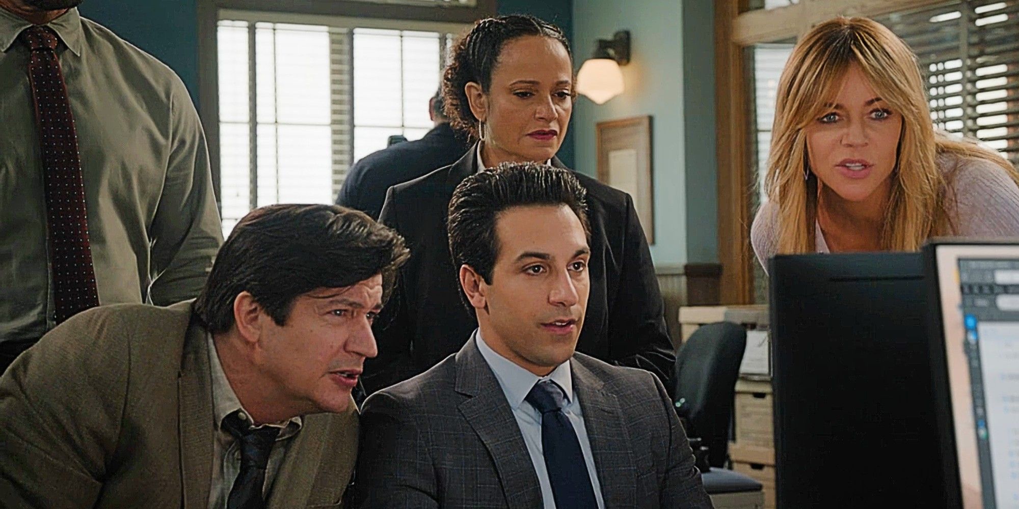 Oz sitting at a desktop computer while Chuck, Selena, and Morgan look over his shoulder in High Potential Season 1 Episode 10