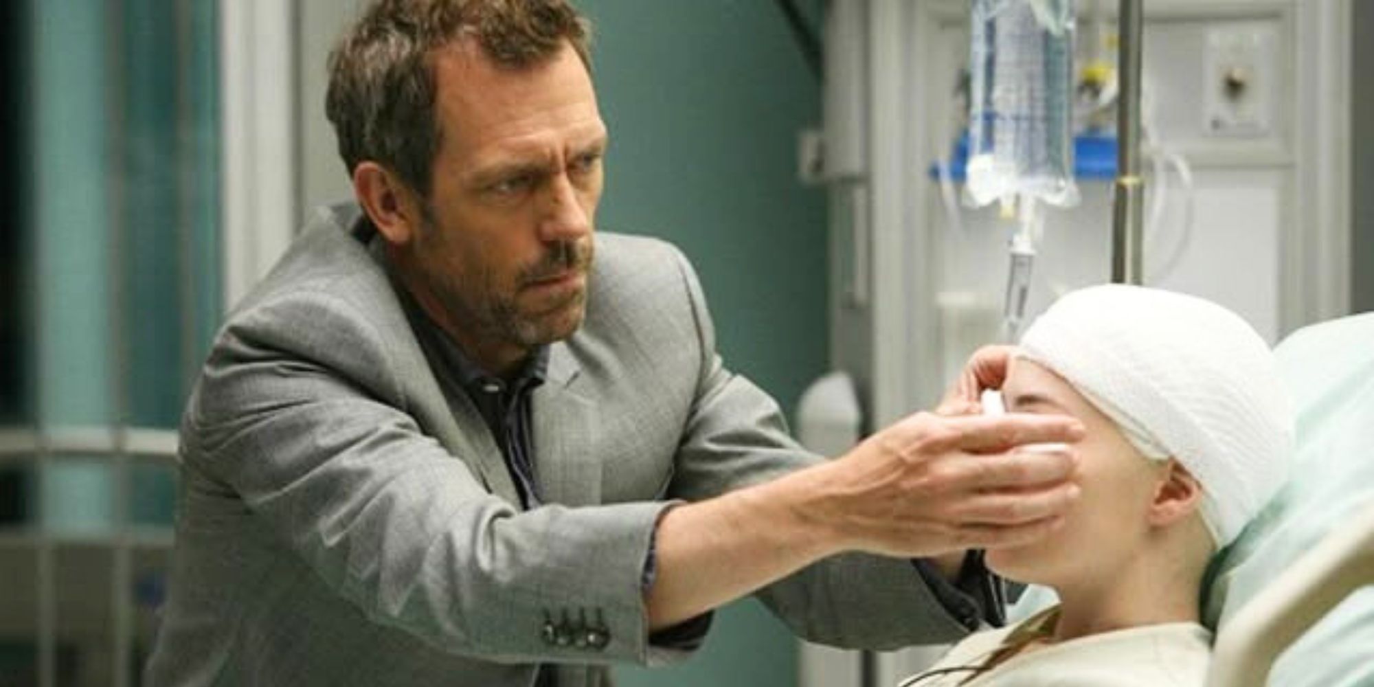 Hugh Laurie tending to a patient&rsquo;s eye who is sitting up in a hospital bed in House episode Birthmarks