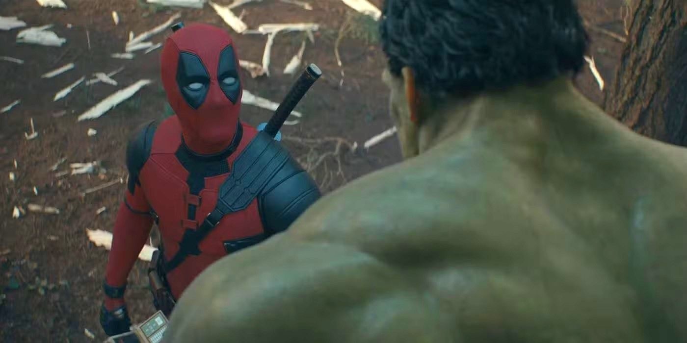 Ryan Reynolds as Deadpool in his supersuit looks up at The Hulk in a forest in Deadpool and Wolverine.