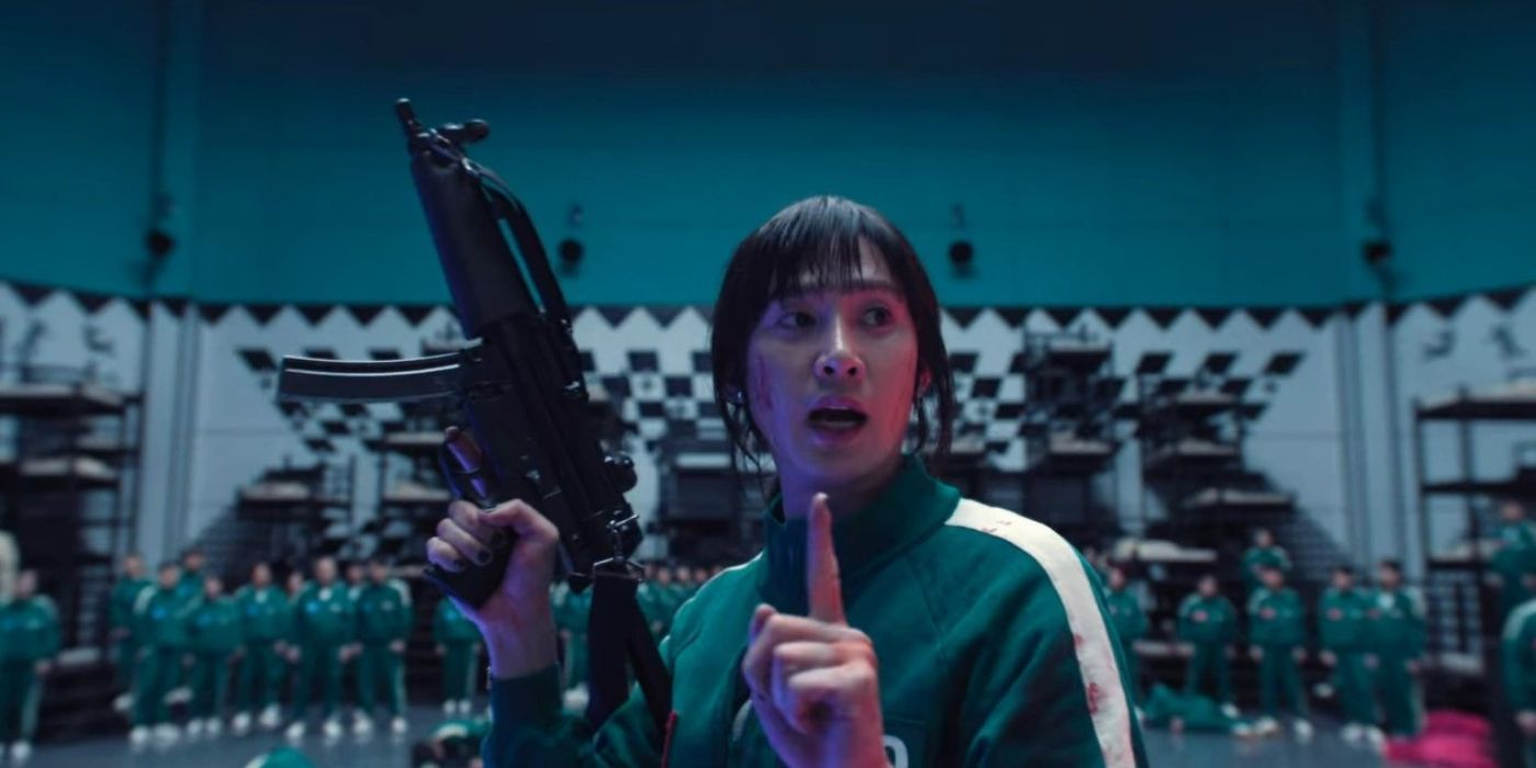 Hyun-ju calls attention to all the other players, holding a gun in Squid Game.