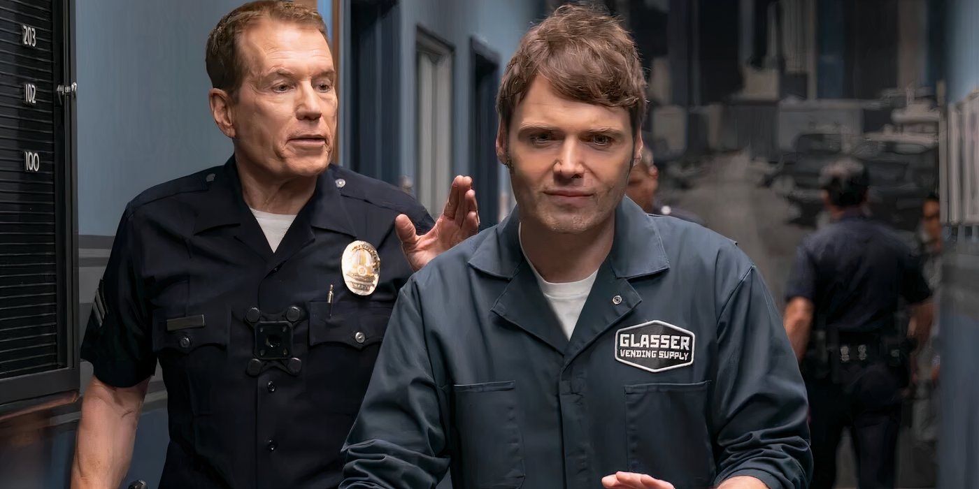 Seth Gabel is smirking while a police officer speaks from behind him in The Rookie Season 7, Episode 5