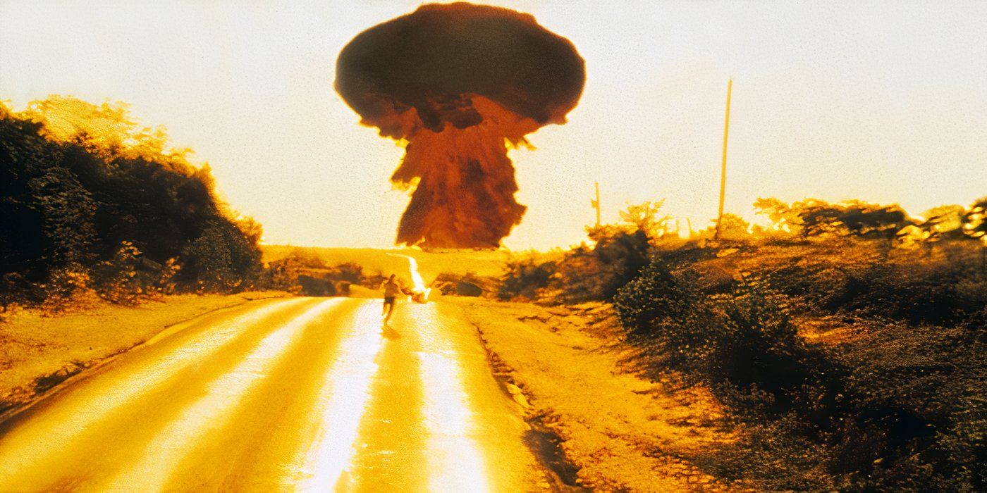 A person running away down a long road as a nuclear mushroom cloud booms behind them in The Day After.