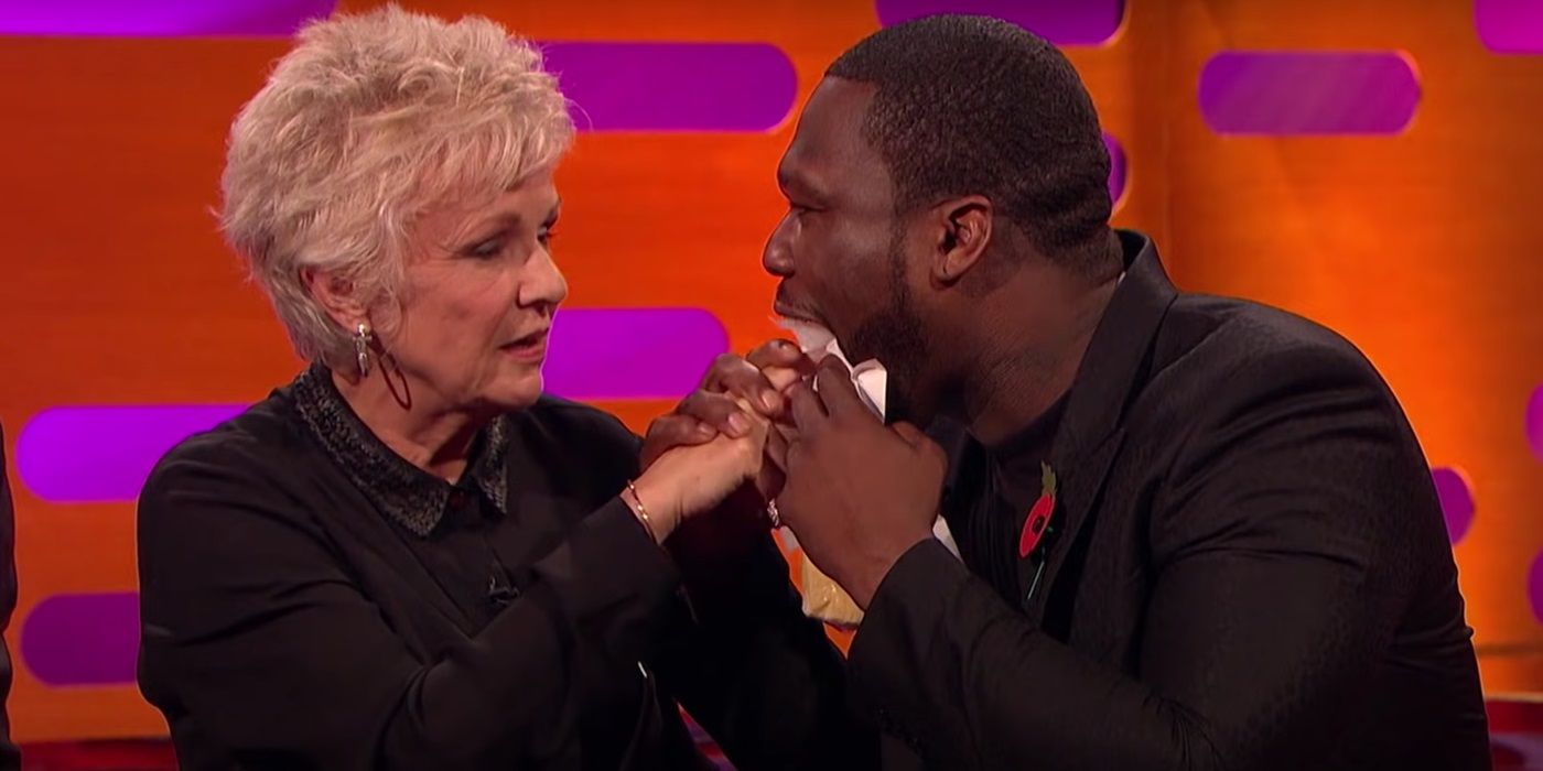 50 Cent holds Julie Walters' hand as she puts it inside his mouth to touch his tongue on The Graham Norton Show