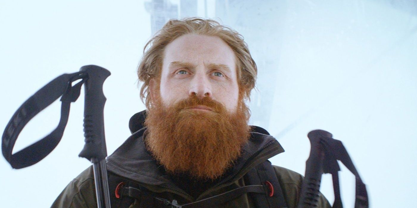 Kristofer Hivju in Force Majeure, standing on a snowy landscape holding skis.