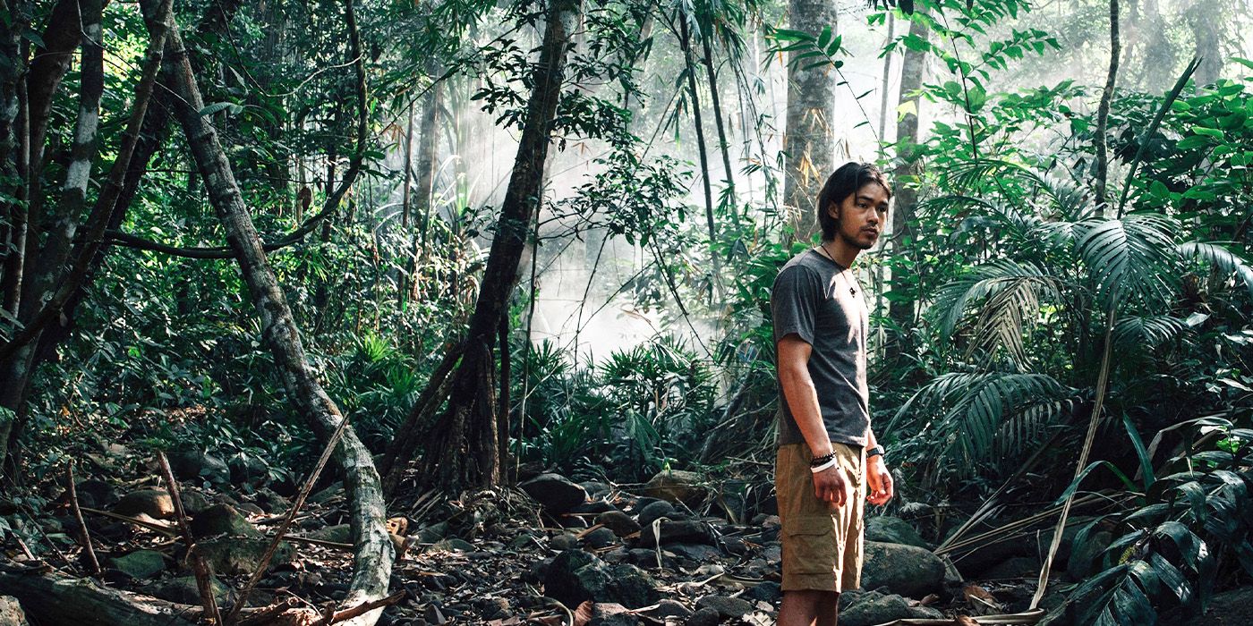 John (Sky Yang) standing in a forested area in Last Days