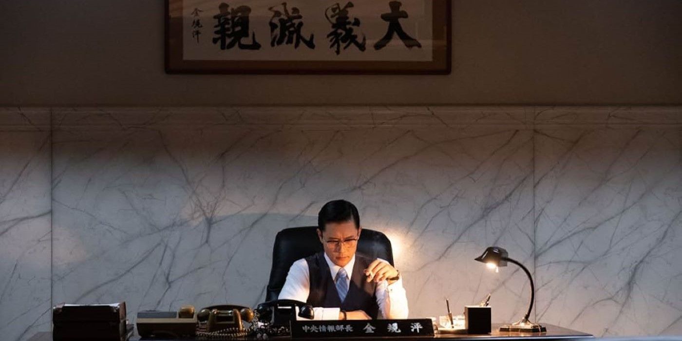 Lee Byung-hun as Kim Kyu-Pyeong sitting behind a desk in The Man Standing Next