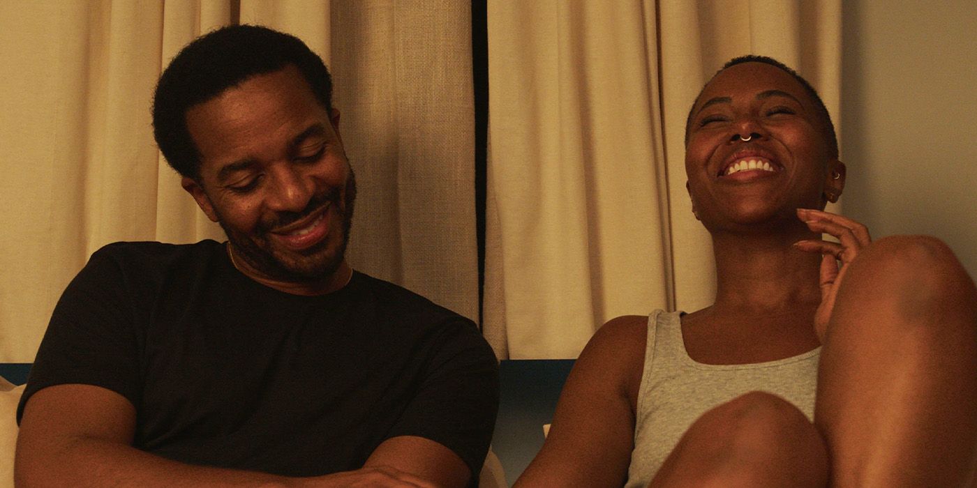 Roger (Andre Holland) and Nicole (DeWanda Wise) laughing on a couch together in Love, Brooklyn