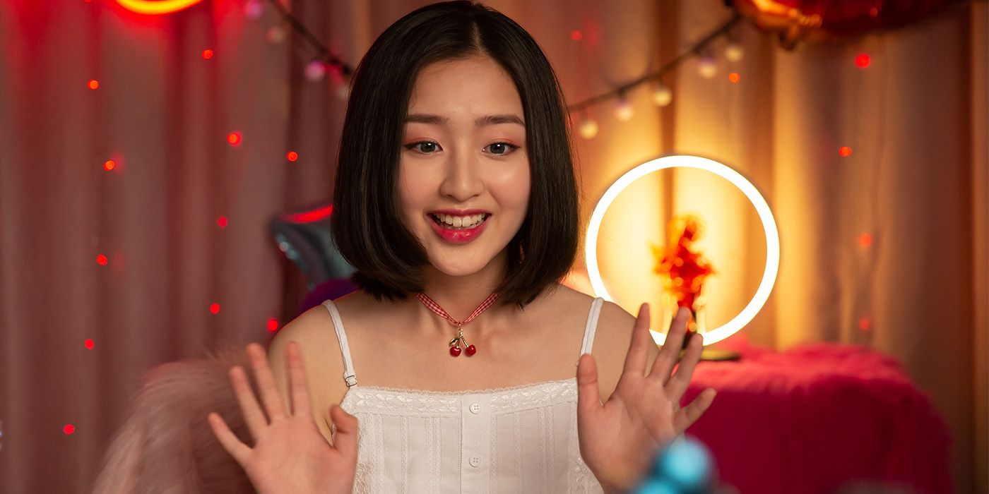 Fa (Enxi Dang) smiling with her hands up waving in Luz