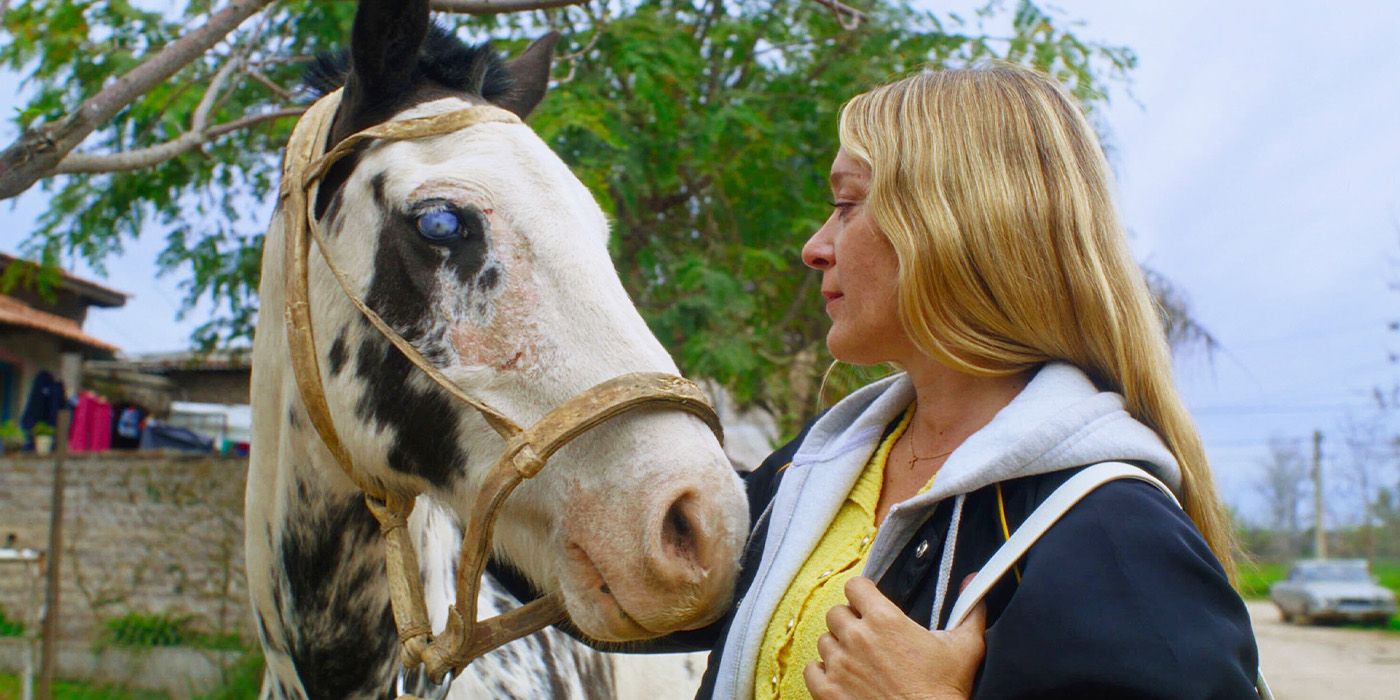 Chloe Sevigny petting a horse in Magic Farm