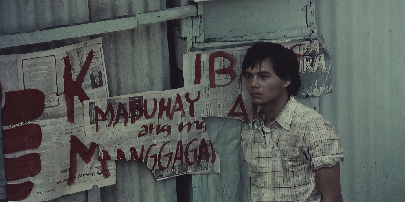 Bembol Roco as Julio standing next to protest signs in 'Manila in the Claws of Light'