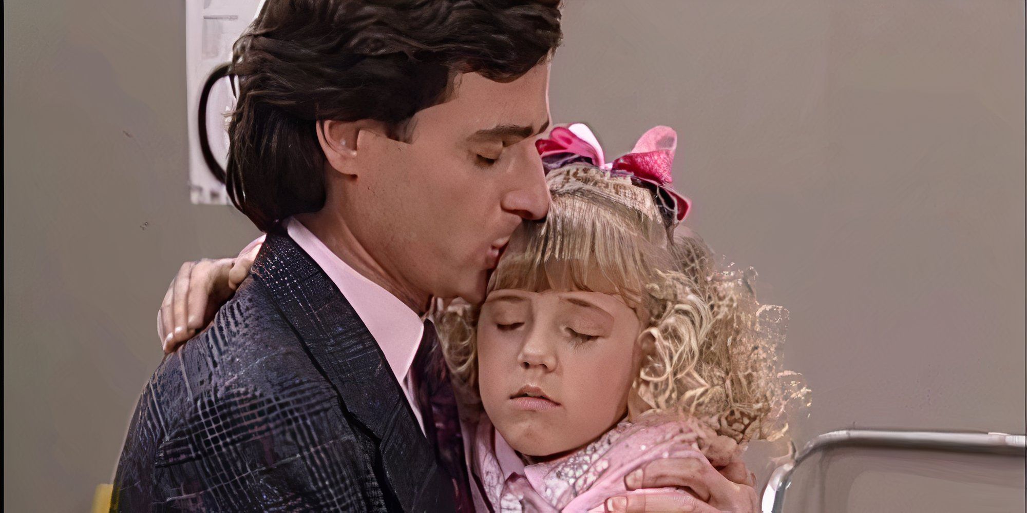 Danny is hugging and kissing his daughter Stephanie who looks upset.