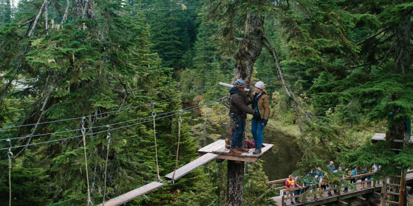 Mel and Jack at the Lumberjack Games, standing on a platform attached to a tree in season 3 of Virgin River.