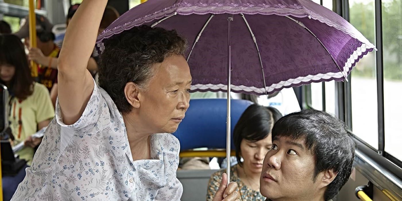 Na Moon-hee holding an umbrella while on the bus in Miss Granny