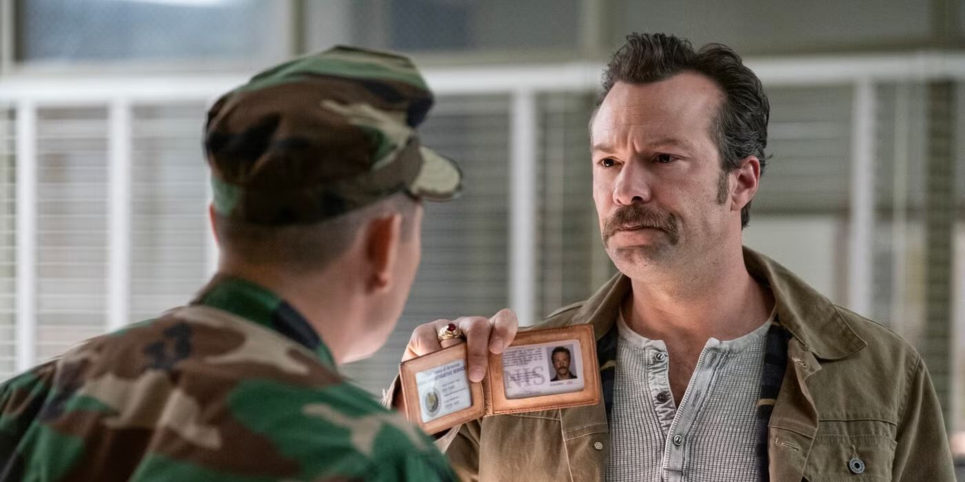 Mike Franks (Kyle Schmid) holding up his NIS identification to a solider in NCIS: Origins
