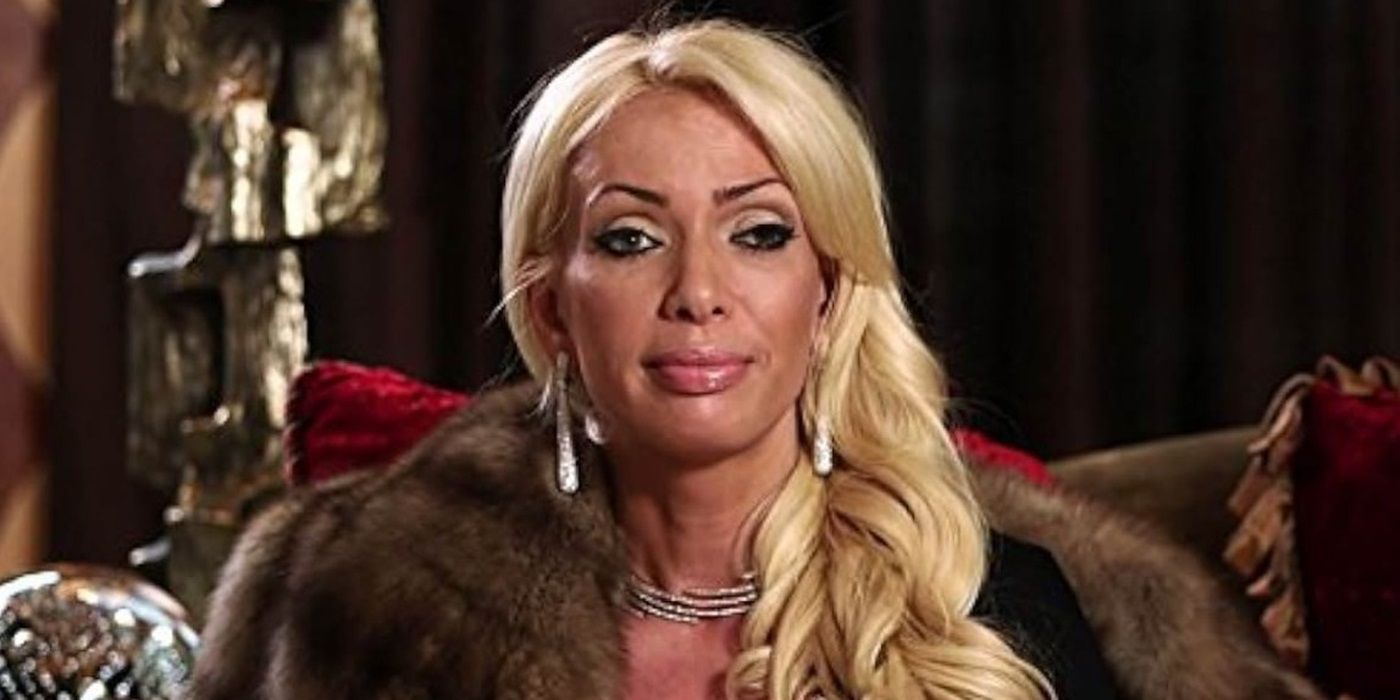 A cast member from the show &lsquo;New Money&rsquo; looks blankly at the camera wearing a fur coat and large earrings.