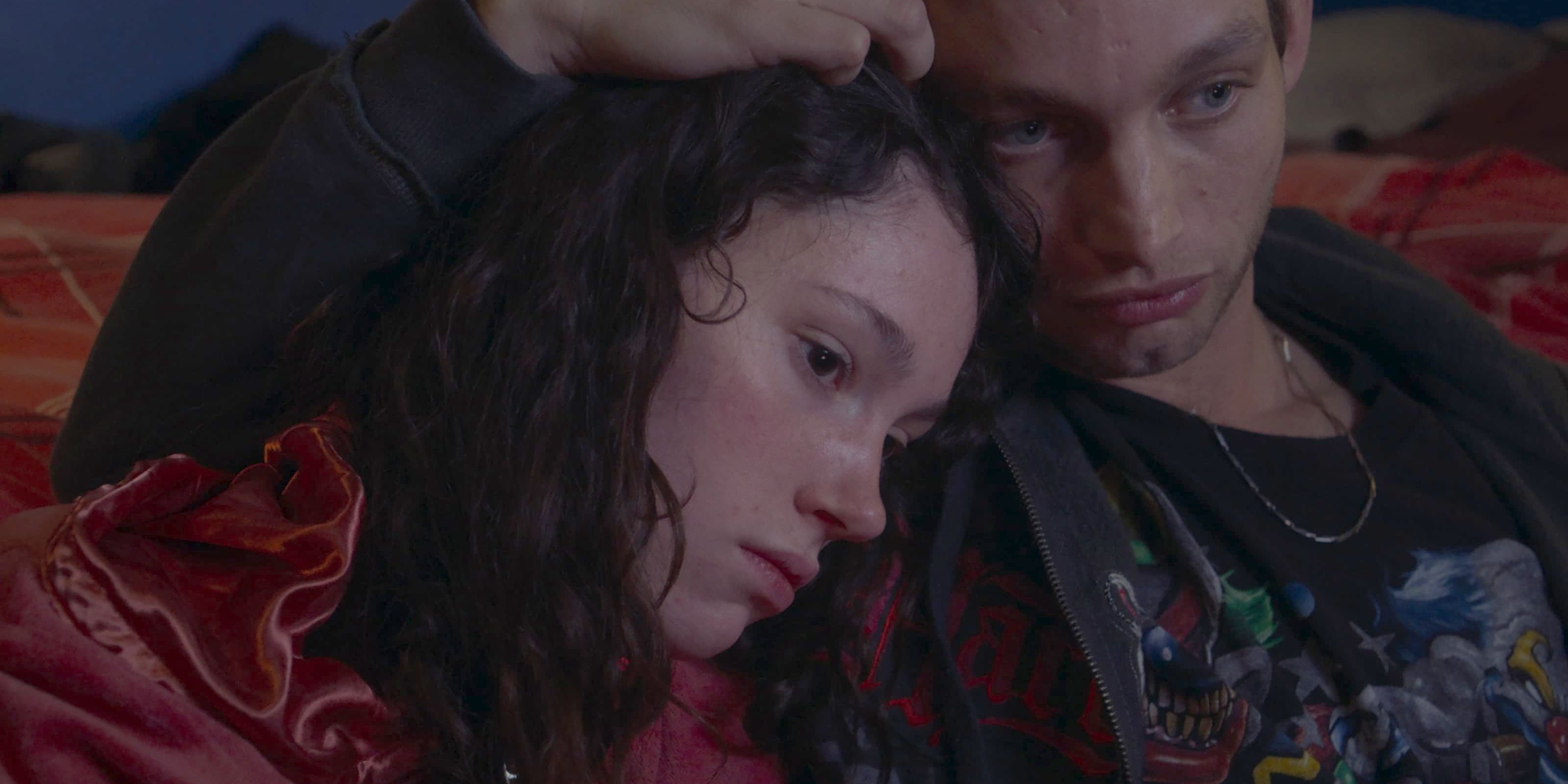 Apo and Pablo, played by actors Lila Gueneau and Théo Cholbi, hold each other and look depressed in Eat The Night.