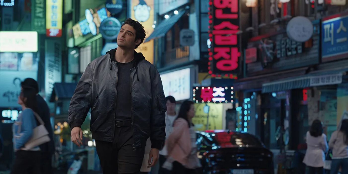 Noah Centineo walking through a busy street in The Recruit Season 2