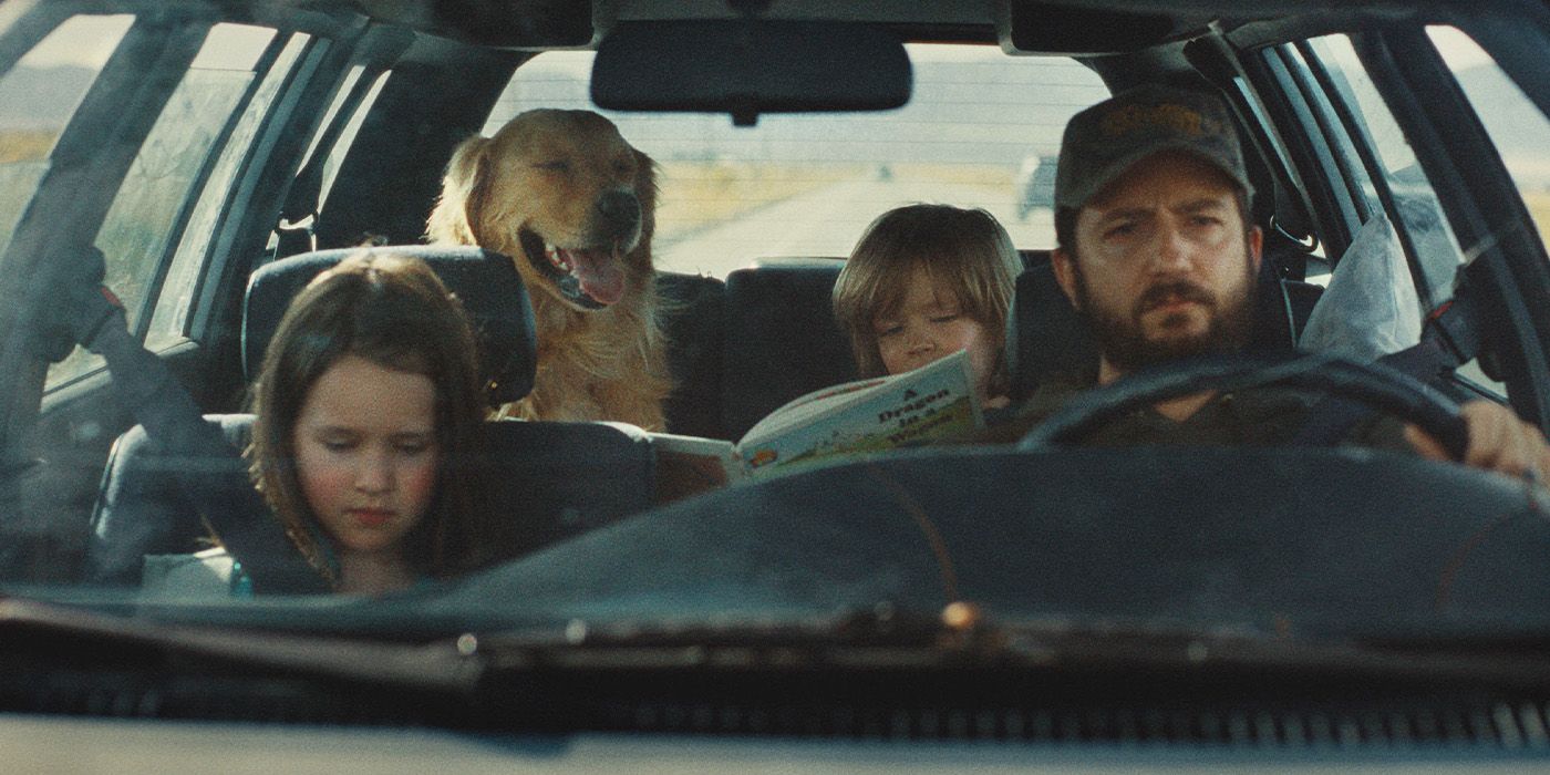 Dad (John Magaro), Ella (Molly Belle Wright) and Charlie (Wyatt Solis) in a car with a dog in Omaha