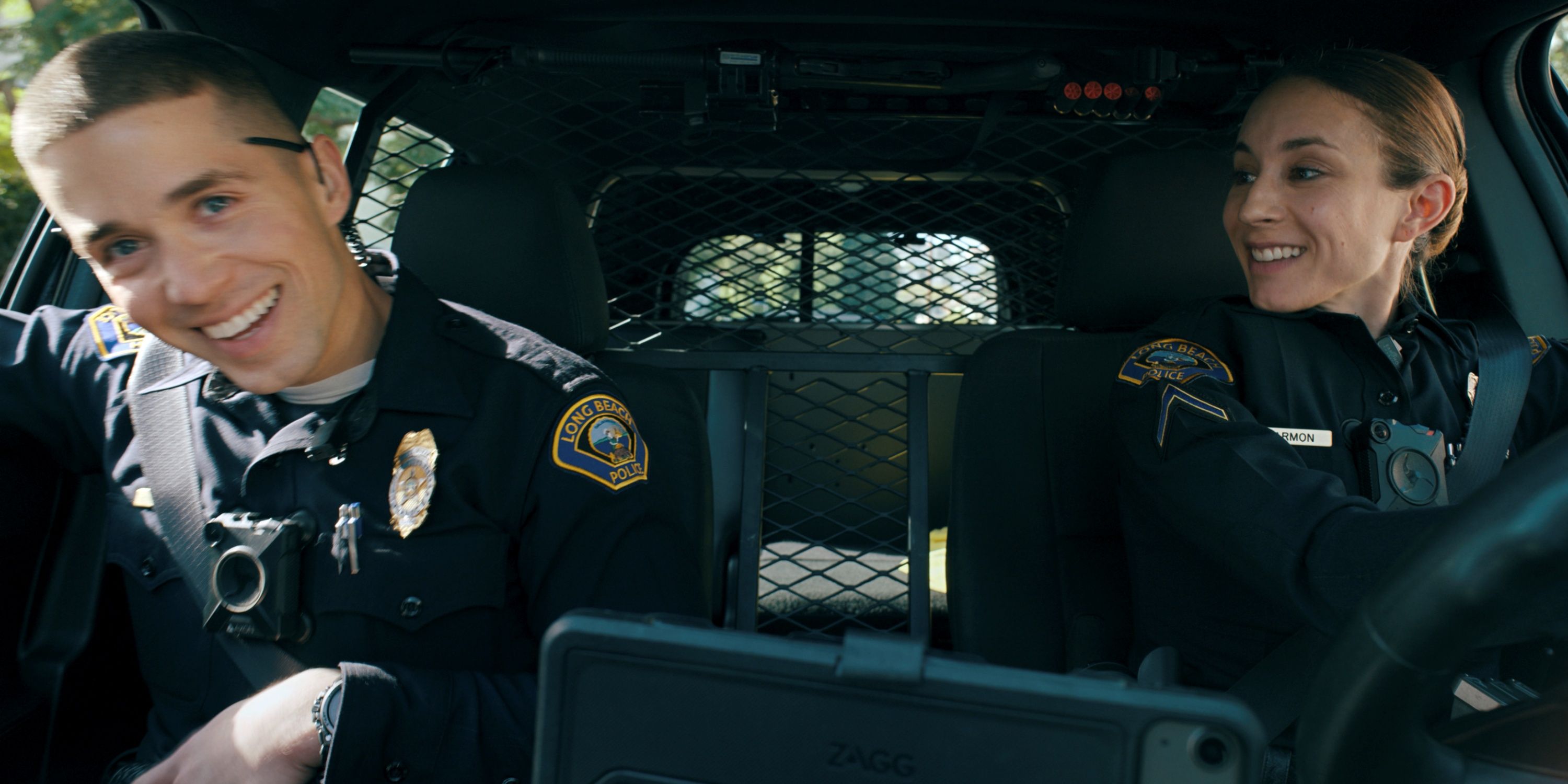 Troian Bellisario as Traci Harmon driving a police car with Brandon Larracunete as Alex Diaz in on Call