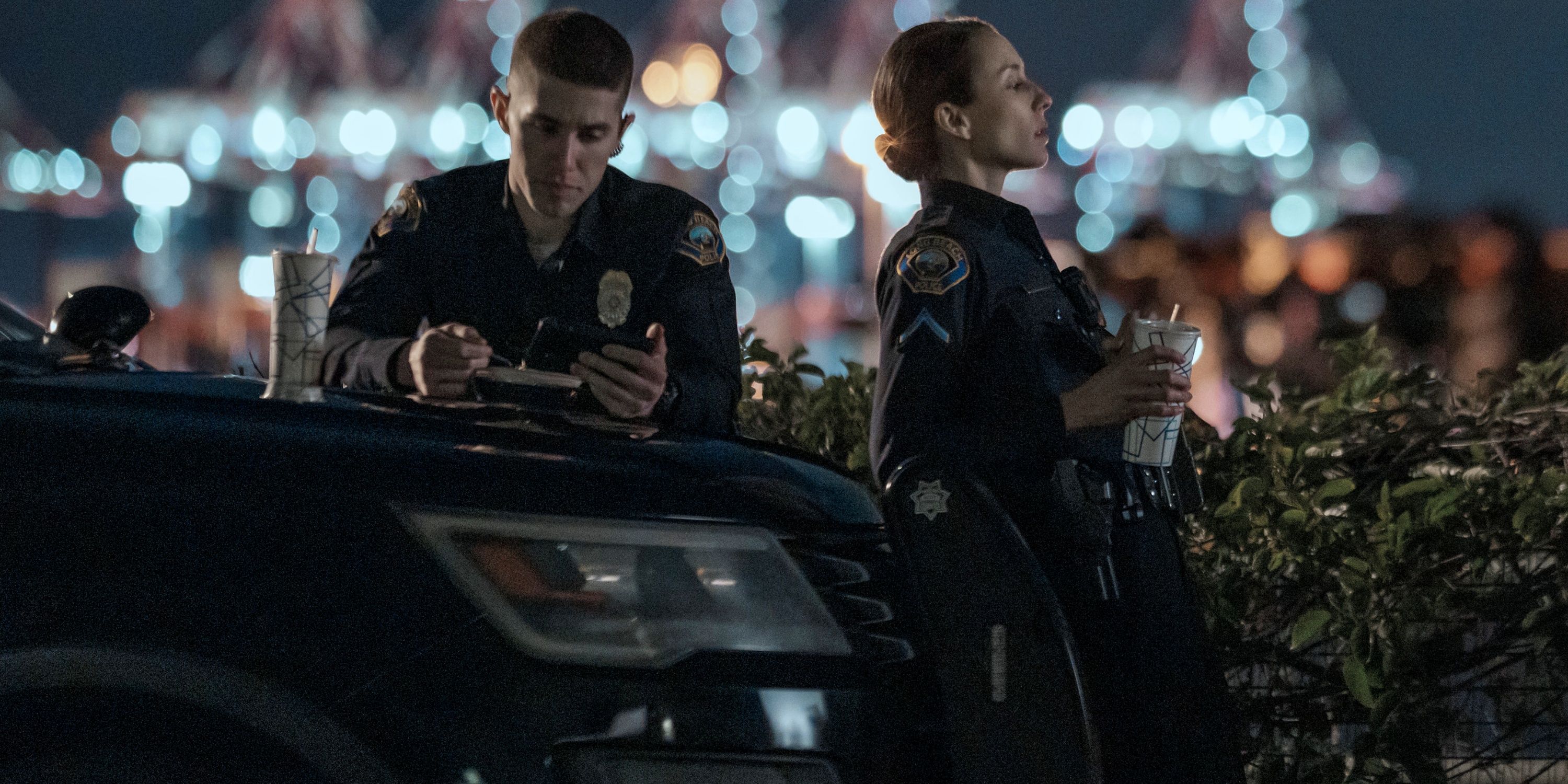 Troian Bellisario as Traci Harmon leaning on a police car next to Brandon Larracunete as Alex Diaz in on Call