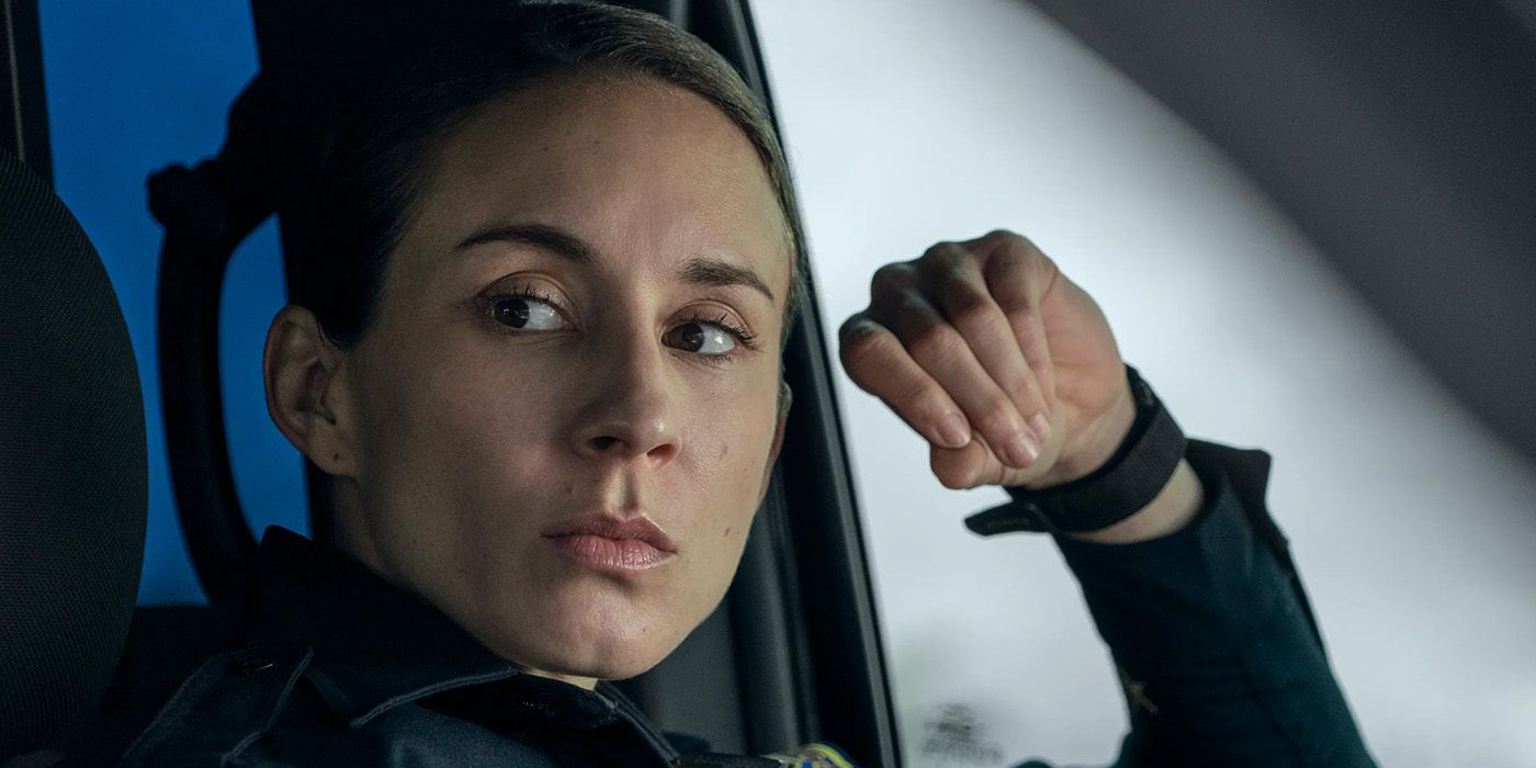 Troian Bellisario in police uniform in the driver's seat looking at someone in Prime Video's On Call