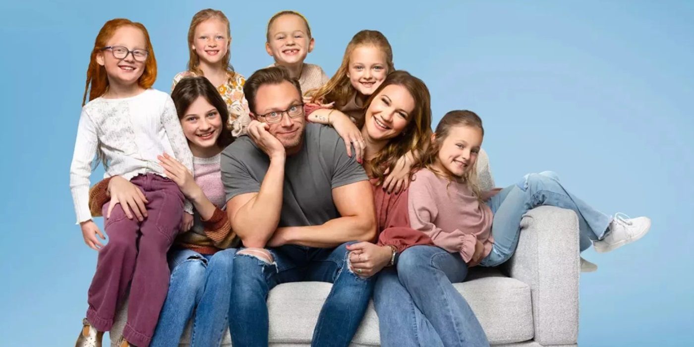 Adam and Danielle Busby and their six daughters pose on a couch with a blue backdrop for Outdaughtered.