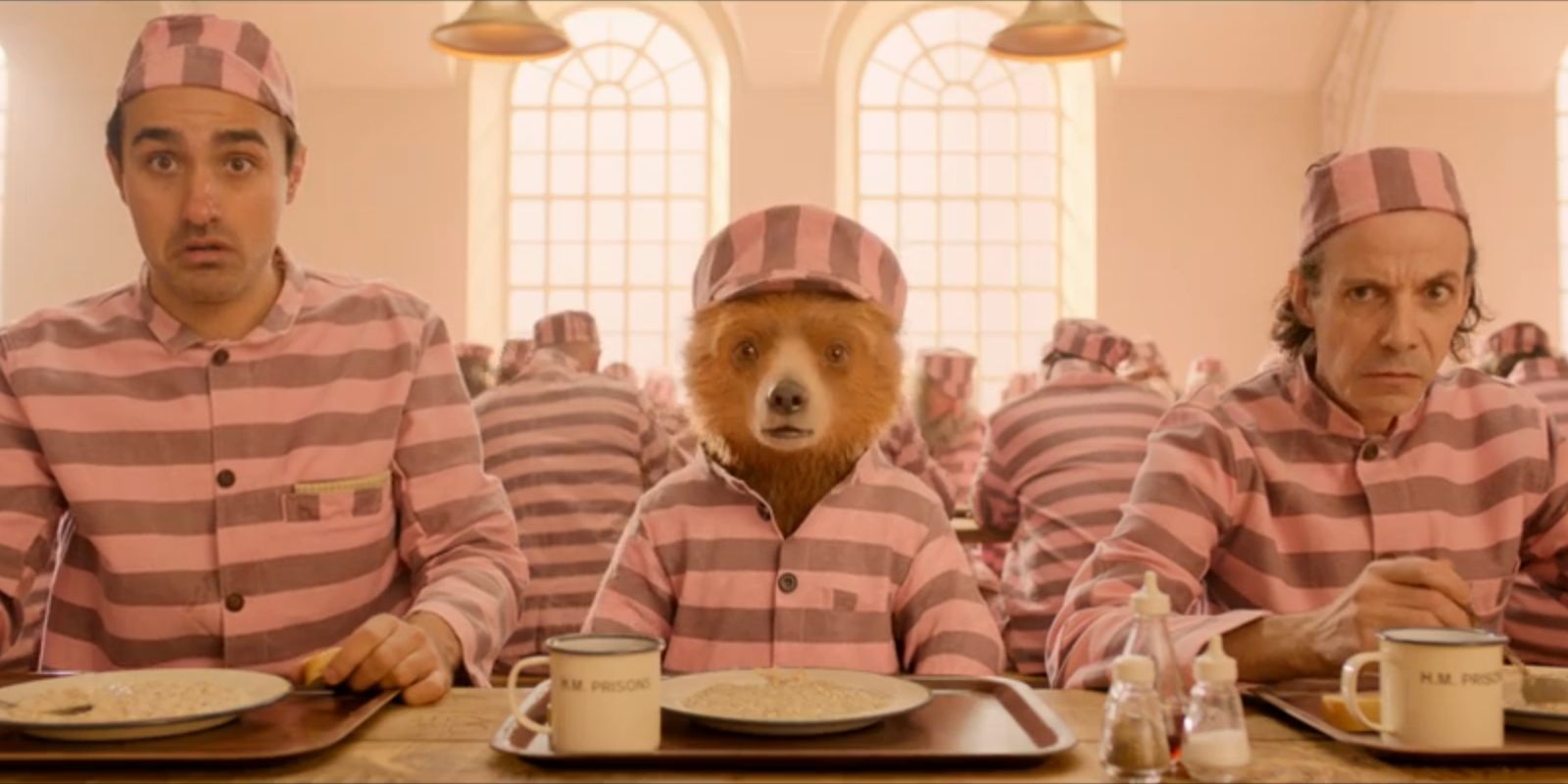 The Professor, Paddington and Phibs all sit at the lunch table while looking alarmed in 'Paddington 2'.