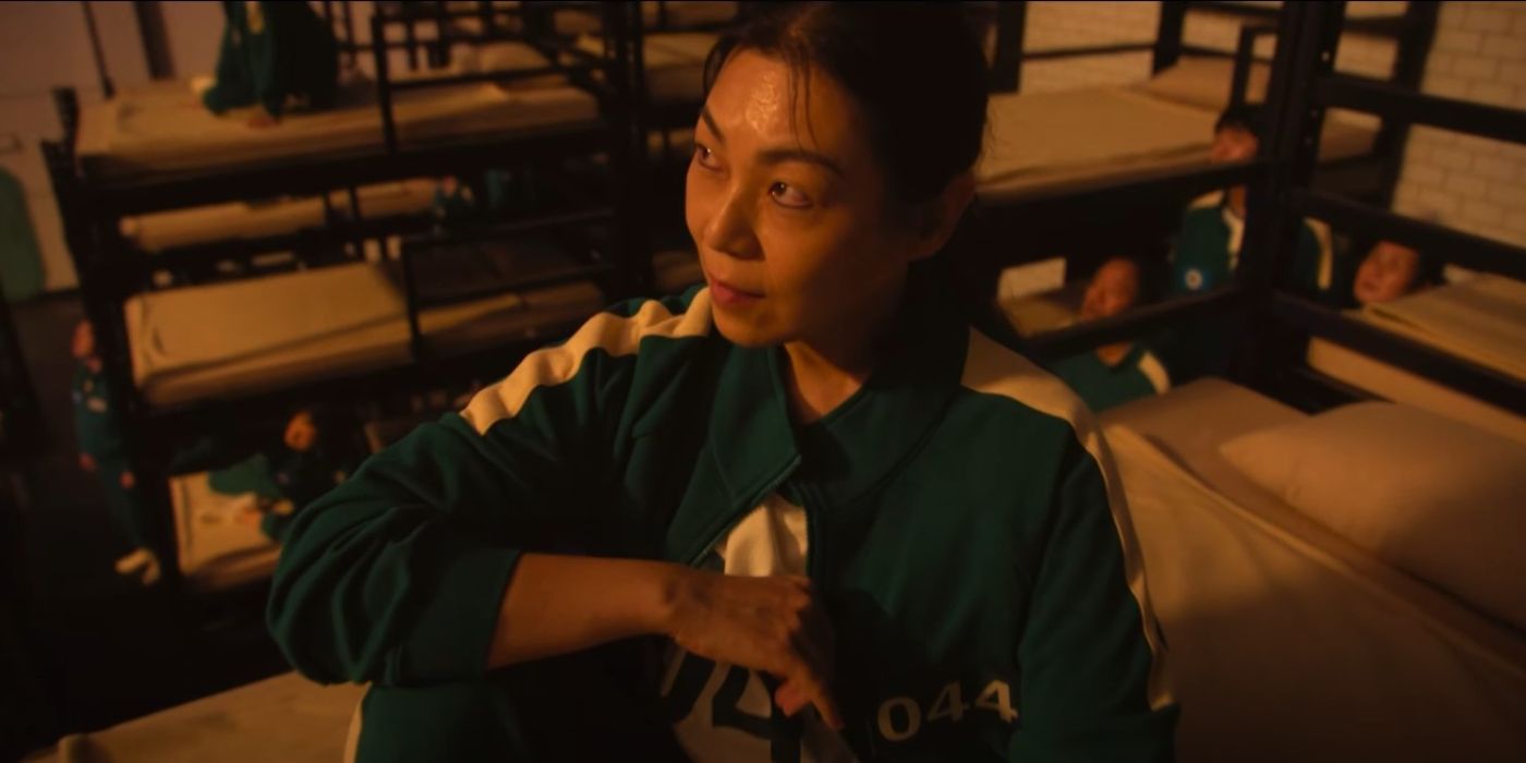 Player 044 aka Seon-nyeo sitting on her bunk bed and looking up at the prize money