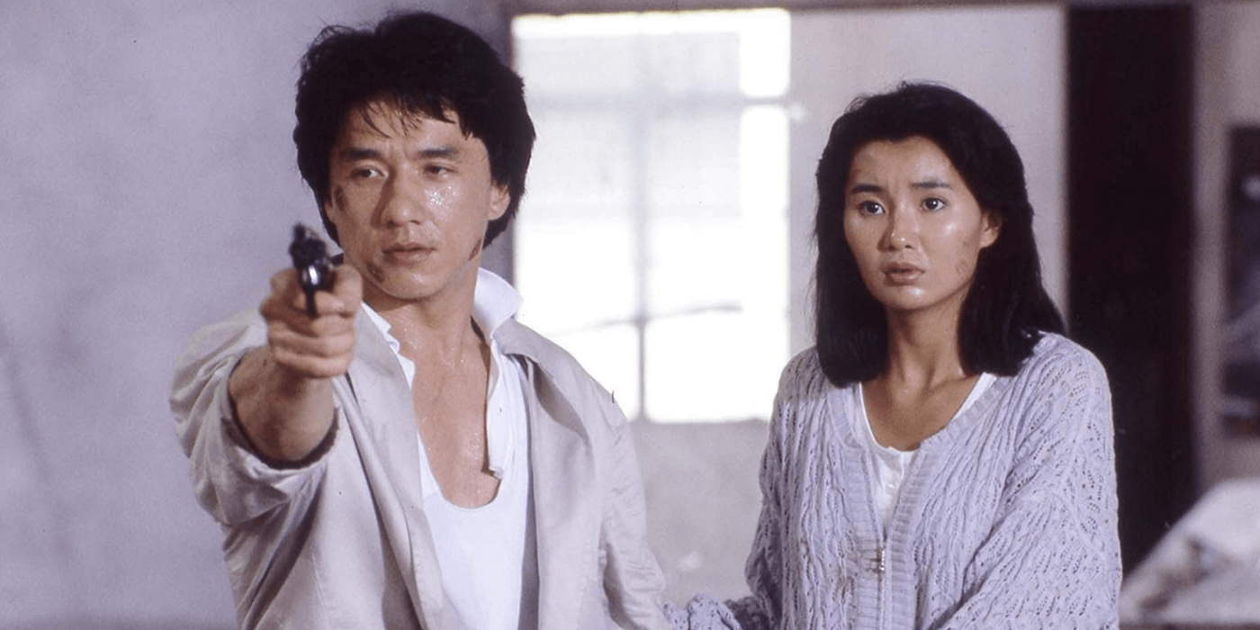 Jackie Chan aiming a gun near Maggie Cheung in Police Story (1985)