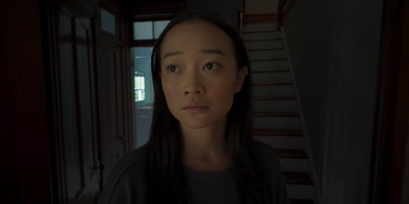 Chloe stands forlornly in a dim doorway in Presence