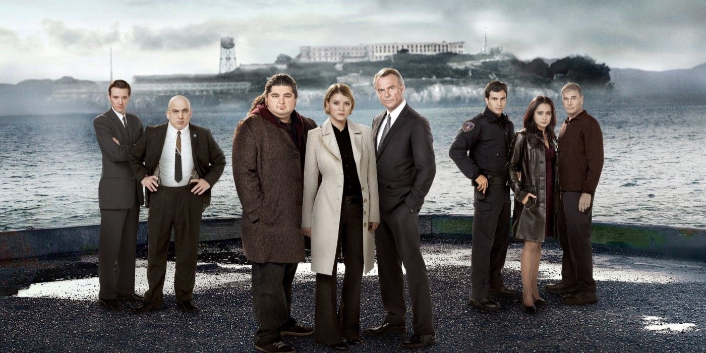 Promotional image featuring the cast of Alcatraz with the prison seen in the background.