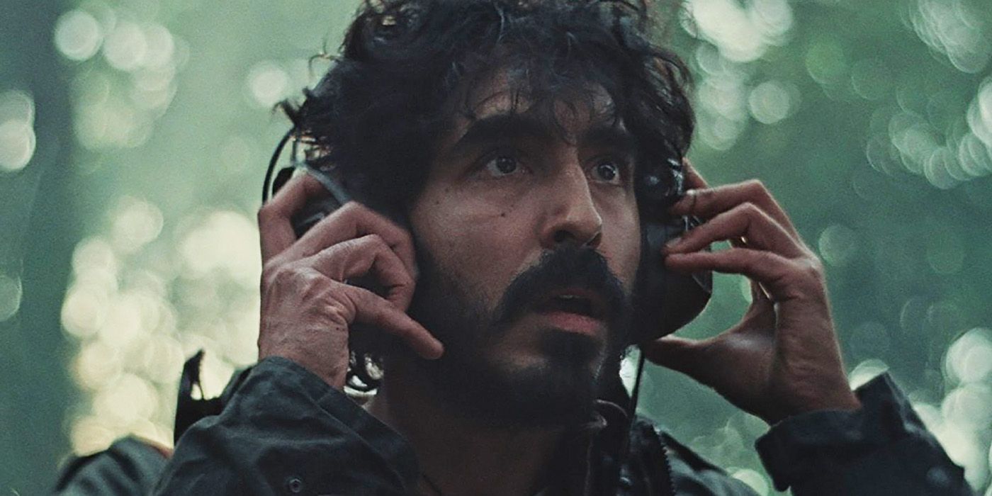 Darcy (Dev Patel) with headphones looking up in fear in Rabbit Trap