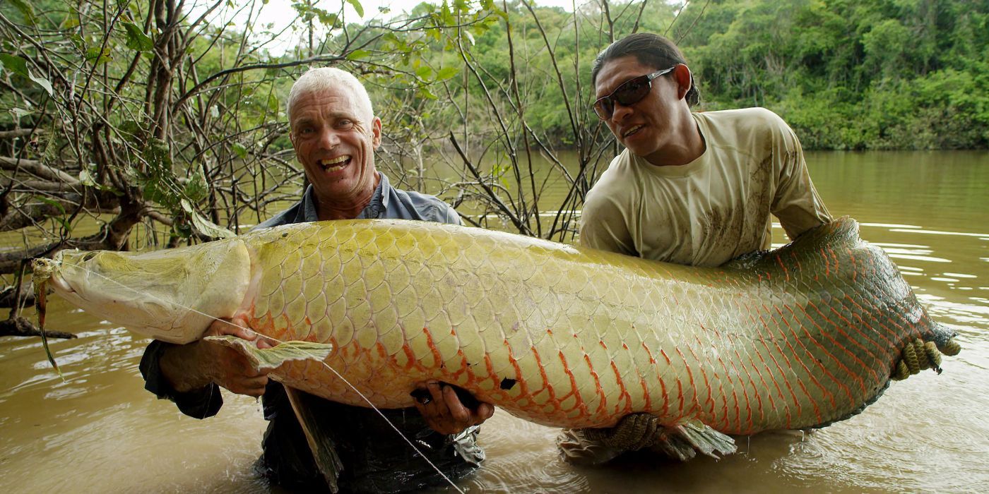 Jeremy Wade holding a massive freshwater fish with another guy on River Monsters.