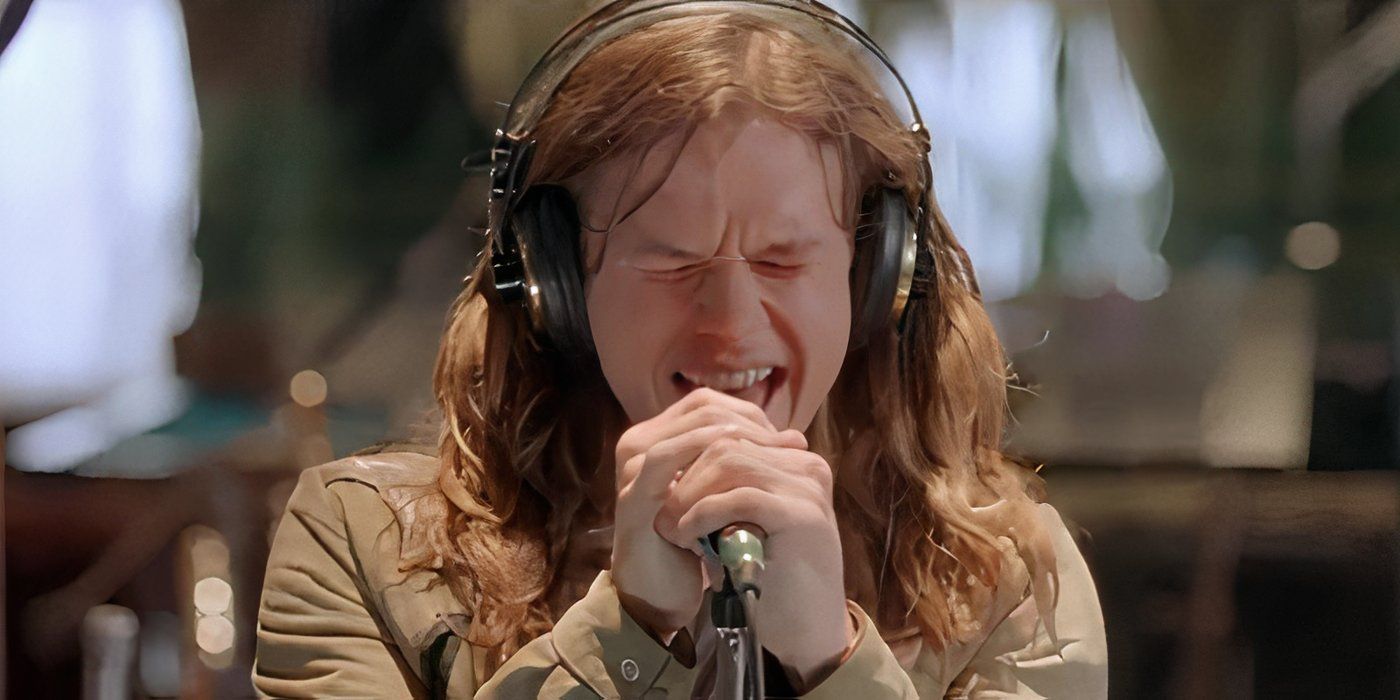 Izzy (Mark Wahlberg) sings into a microphone while wearing headphones in 'Rock Star' (2001)