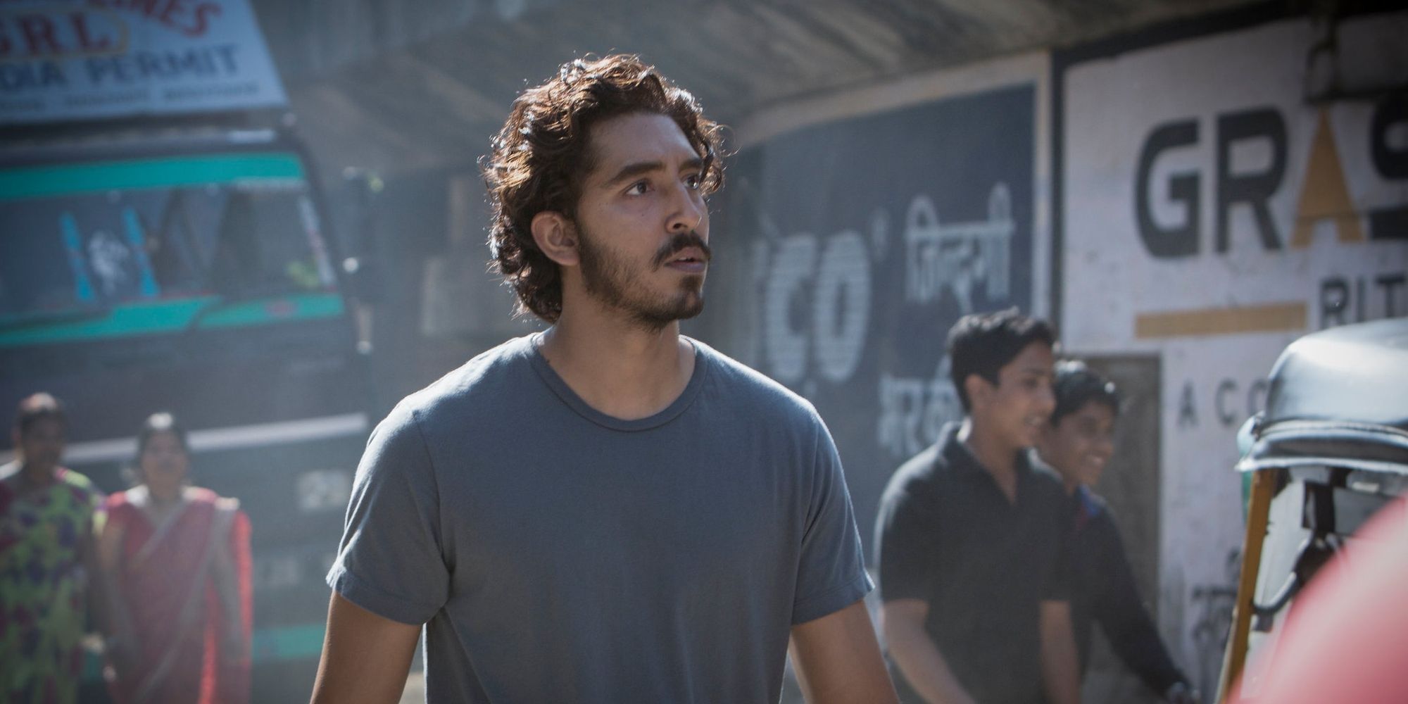 Saroo (Dev Patel) walking down a busy street in India in Lion.