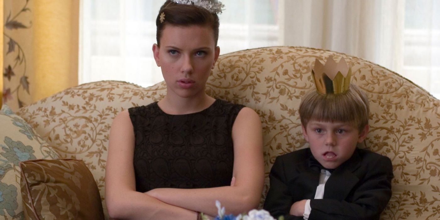 Scarlett Johansson and Nicholas Art wearing party crowns with arms crossed in The Nanny Diaries.