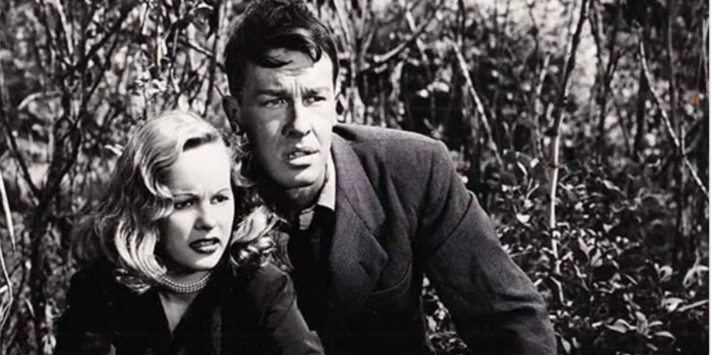 John Dahl and Peggy Cummins as Bart and Annie wearing black hiding in the trees in &lsquo;Gun Crazy&rsquo;