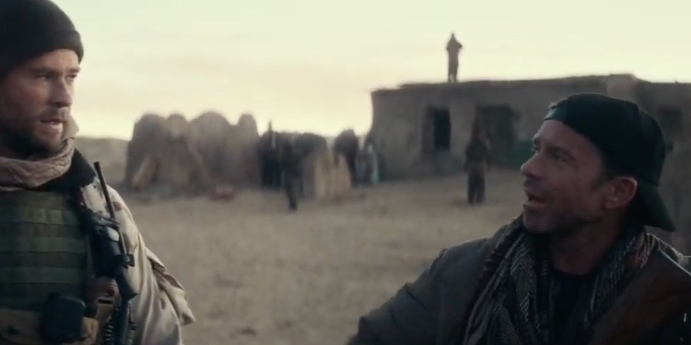 Chris Hemsworth talks to Taylor Sheridan in military uniforms outside a desert hut in 12 Strong.