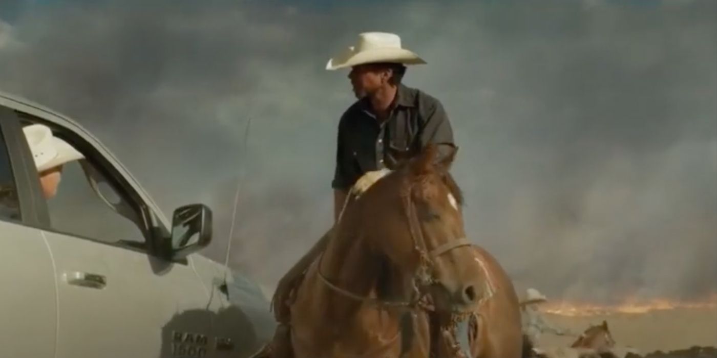 Taylor Sheridan riding a horse with a white cowboy hat talking to someone in a white car in Hell or High Water.