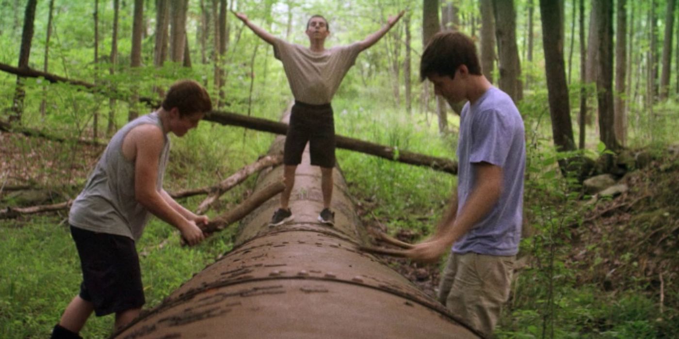 Gabriel Basso, Moises Arias, Nick Robinson as Patrick, Biaggo, and Joe standing on metal pipe banging with wood branches in &lsquo;The Kings of Summer&rsquo;