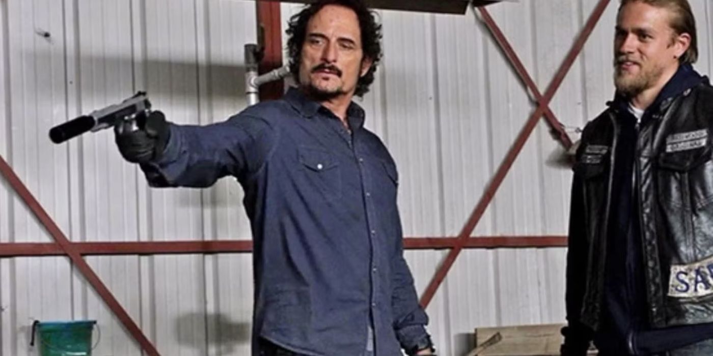 Tig (Kim Coates) holds a weapon, about to kill Damon Pope as Jax (Charlie Hunnam) looks on in Sons of Anarchy.